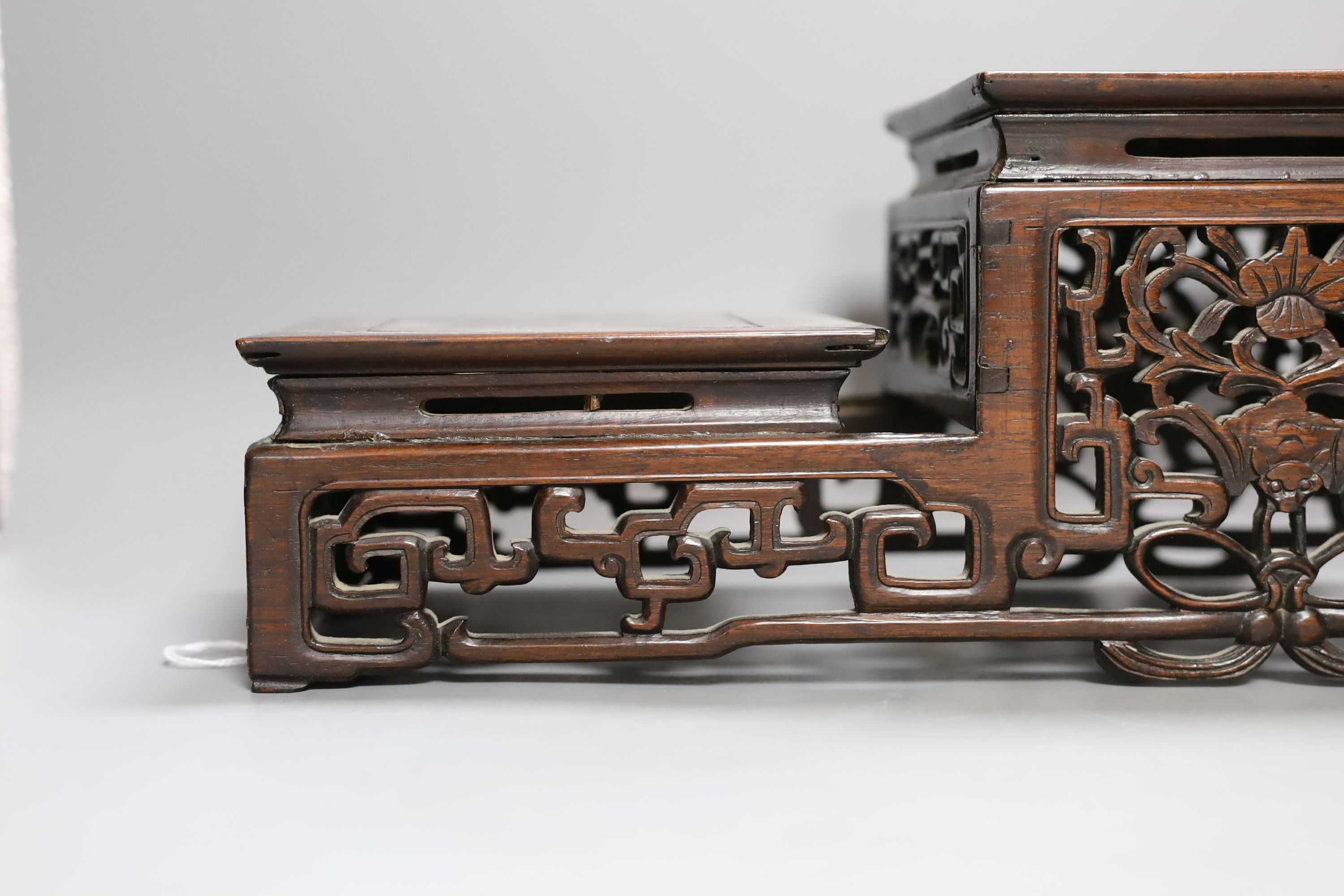 A Chinese carved hardwood 3 tier stand, late Qing, together with other similar stands. Largest 49cm